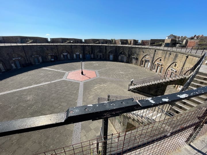 View down into a circular parade ground of a fortress with a deep blue sky